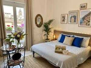 a bedroom with a bed with blue pillows and a table at Gioia B&B in Cirò Marina
