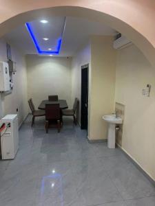 a room with a table and chairs and a blue light at ifetomitola in Iseri-Osun