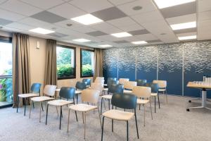 a conference room with chairs and tables and windows at Hôtel Antares & Spa in Honfleur