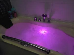 a purple bath tub with a pink light in it at Zen Olive Guest Room in Antwerp