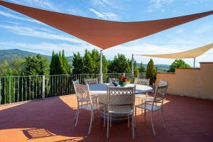 a table and chairs on a patio under a large umbrella at Agriturismo Luggiano in Vinci