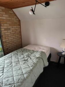 a bedroom with a bed and a brick wall at Villa With Three Bedrooms in Vemb