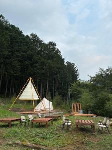 a group of picnic tables and tents in a field at 川辺の時-Kawabe 川-山-BBQ in Hanno