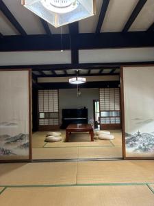 a large room with a table and a piano at 川辺の時-Kawabe 川-山-BBQ in Hanno