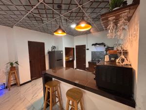 a kitchen with a counter and two stools at Mulberry Villa in Anuradhapura
