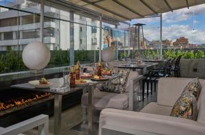 a restaurant with tables and chairs and a fireplace at Grand Colony Hotel in Bogotá