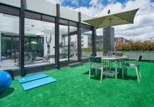 a patio with green carpeting and a table and chairs at Grand Colony Hotel in Bogotá