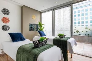 a bedroom with two beds and a large window at Grand Colony Hotel in Bogotá