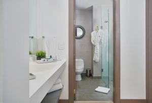 a bathroom with a toilet and a glass shower at Grand Colony Hotel in Bogotá +39 photos
