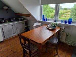 a dining room with a wooden table and a window at Bed en Boterham in Hedel