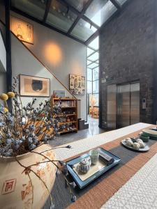 ein Wohnzimmer mit einem Tisch und einer großen Vase in der Unterkunft Interlude Inn, Boutique Art Retreat, Cultural Experience, Artisan Breakfast in Fenghuang