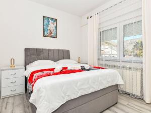 a bedroom with a large bed and a window at Apartment Dijana by Interhome in Donji Proložac