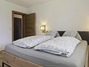 a bed with two pillows on top of it at Apartment Eben by Interhome in Hippach