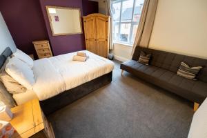 a small bedroom with a bed and a couch at Family Friendly I Pets Welcome I Short Walk to Railway Station I 10min Drive to Safari Park in Kidderminster