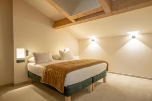 a bedroom with a large bed with two lights at Résidence San Petru - 4 étoiles in Porto-Vecchio