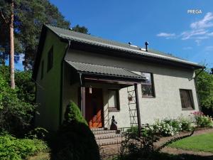 a small white house with a green roof at Molly and Butter in Valmiera