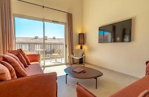 a living room with a couch and a tv at Résidence San Petru - 4 étoiles in Porto-Vecchio