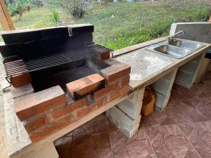 a kitchen with a sink and a stone counter at GranjaKatKery in Cerro Azul