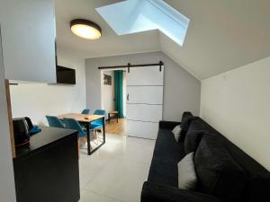 a living room with a black couch and a table at Apartamenty Chata u Rybaka in Jantar