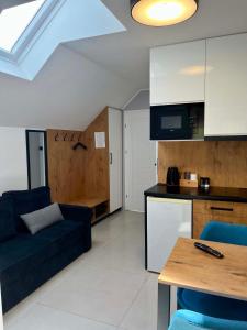 a living room with a couch and a kitchen at Apartamenty Chata u Rybaka in Jantar