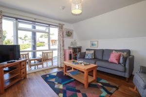 a living room with a couch and a tv at Coombe Lodge No 9 in Bude