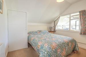 a bedroom with a bed and a window at Coombe Lodge No 9 in Bude