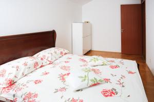 a bedroom with a bed with a floral bedspread at Apartment DV Magnolia in Tivat