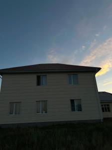 a large house with a sky in the background at Уметалиев Канат in Birlik