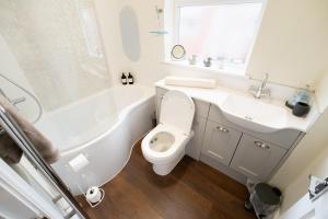 a white bathroom with a toilet and a sink at Family Friendly I Pets Welcome I Short Walk to Railway Station I 10min Drive to Safari Park in Kidderminster +28 photos