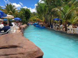 a pool at a resort with people in the water at Spazzio diRoma in Caldas Novas