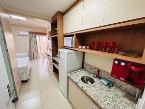 a small kitchen with a sink and a refrigerator at Spazzio diRoma in Caldas Novas