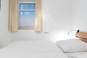 a bedroom with two beds and a window at Haus Roland, Wohnung 16 in Zinnowitz