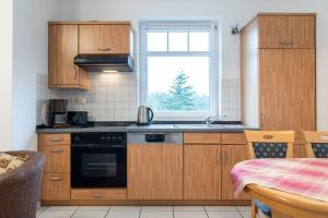 a kitchen with wooden cabinets and a window at Haus Roland, Wohnung 16 in Zinnowitz
