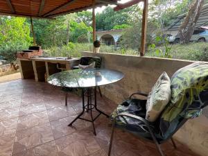 a patio with a table and a chair and an umbrella at GranjaKatKery in Cerro Azul