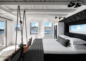 a bedroom with a swinging bed with windows at Captain Zeppos in Pollonia +109 photos