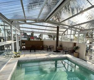 an indoor swimming pool with a glass ceiling and a patio at Marchetti Hotel Comedor in Miramar