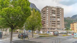 a street with a building and trees in a city at Apartment house Lötschberg in Naters