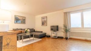 a living room with a couch and a tv at Apartment house Lötschberg in Naters