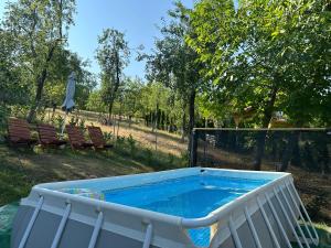 a large swimming pool in a yard with two benches at Vikendica Cokori - private pool and jacuzzi in Banja Luka