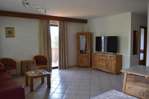 a living room with a flat screen tv on a wooden cabinet at Sonnen Residence in Collalbo +26 photos