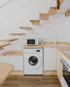 a washer and dryer in a kitchen with a staircase at La cochera by Óscar Fuentes in Alcocer de Planes