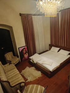 a bedroom with a bed and a chandelier at Menekşe Sultan Köşkü Otel Oda 2 in Burunabat