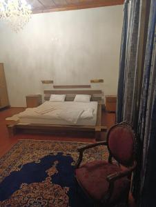 a bedroom with a bed and a chair at Menekşe Sultan Köşkü Otel Oda 2 in Burunabat +6 photos