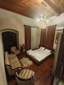 a bedroom with a bed and a chandelier at Menekşe Sultan Köşkü Otel Oda 2 in Burunabat