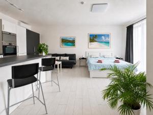 a kitchen and a living room with a bed and a table at RUMAKO apartments in Prague