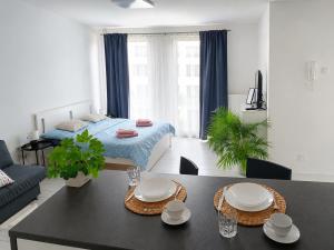 a living room with a bed and a dining table at RUMAKO apartments in Prague