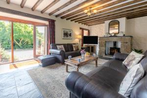 a living room with leather furniture and a fireplace at 3 Bed in Bodmin oc-ltbra in Cardinham
