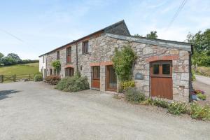 an old stone house with wooden doors and a driveway at 3 Bed in Bodmin oc-ltbra in Cardinham