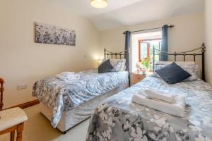 two beds sitting next to each other in a bedroom at 3 Bed in Bodmin oc-ltbra in Cardinham
