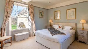 a bedroom with a bed and a large window at Almsbury Farmhouse in Winchcombe